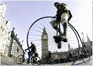 عبور يك دوچرخه سوار با دوچرخه بزرگ از مقابل پارلمان بريتانيا – لندن